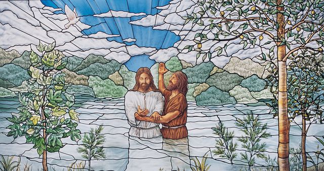 stained glass window of Jesus being baptised